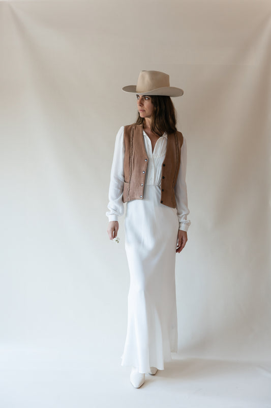 Dahlia maxi dress in Cloud, studio front view styled with a tan leather vest and cowboy hat