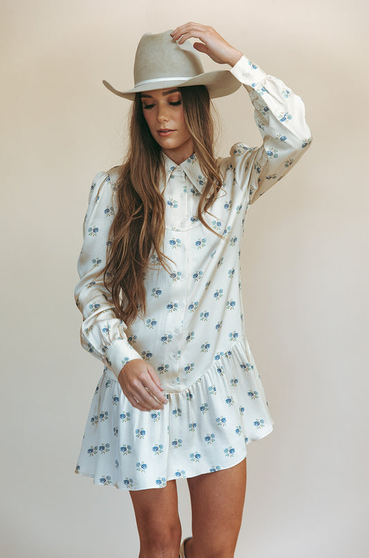Sienna mini dress in Kindred Floral, three-quarter view holding the brim of a gray hat
